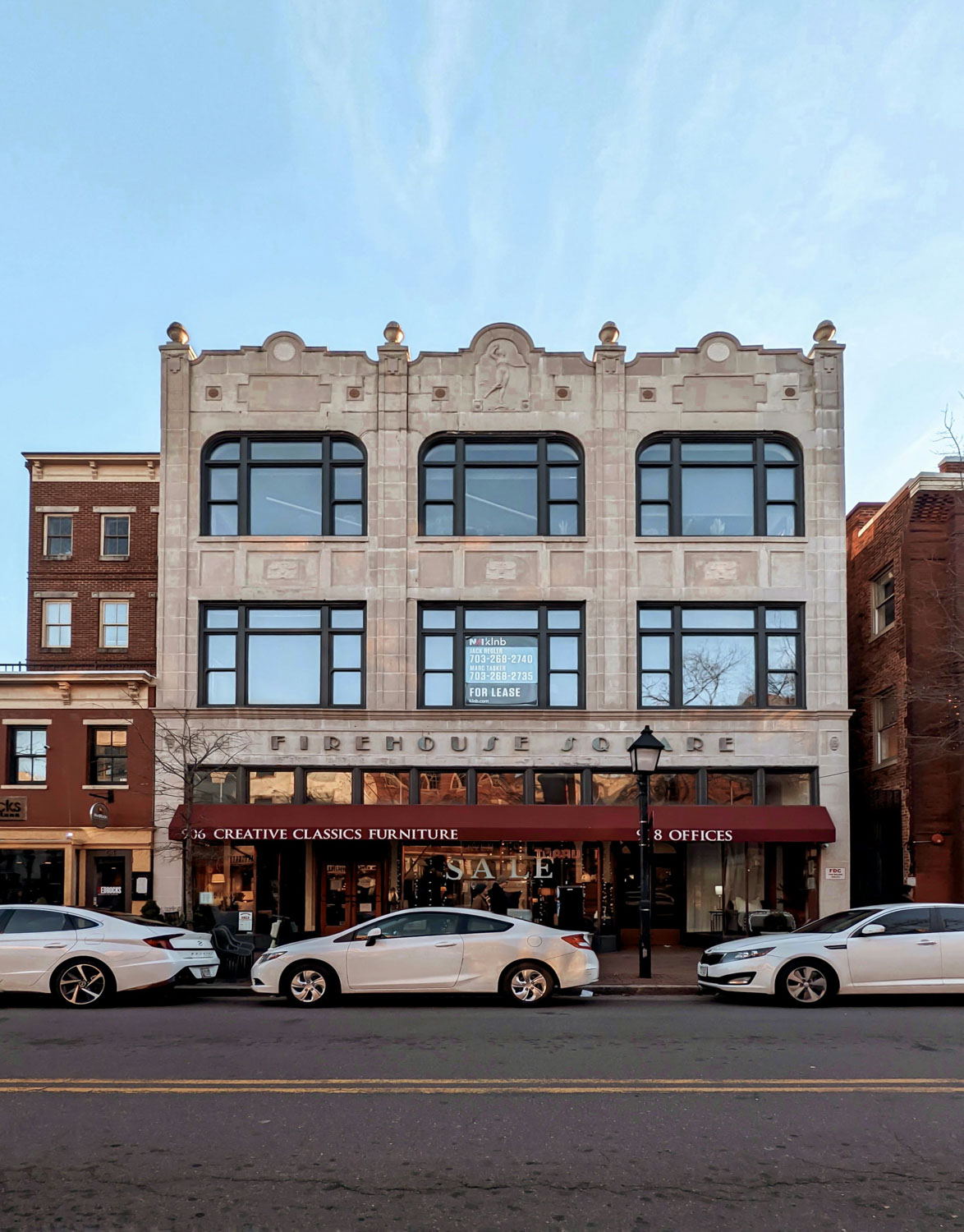 A street view of a building in Alexandria, Virginia with cars parked on the side of the road.