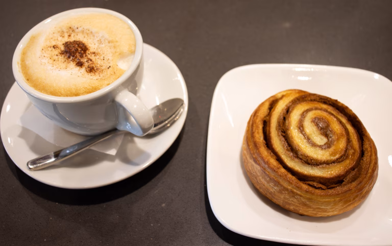 cinnamon roll and coffee at nozzo pazzo delicatessen in vienna, virginia