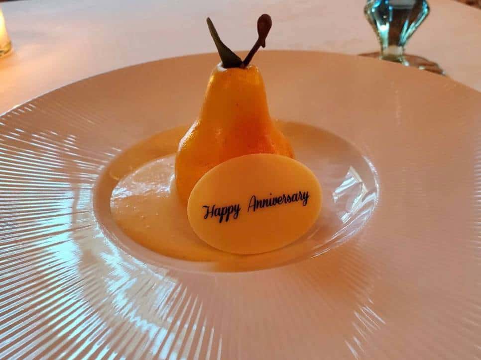 Pear dessert on plate with "Happy Anniversary" message.