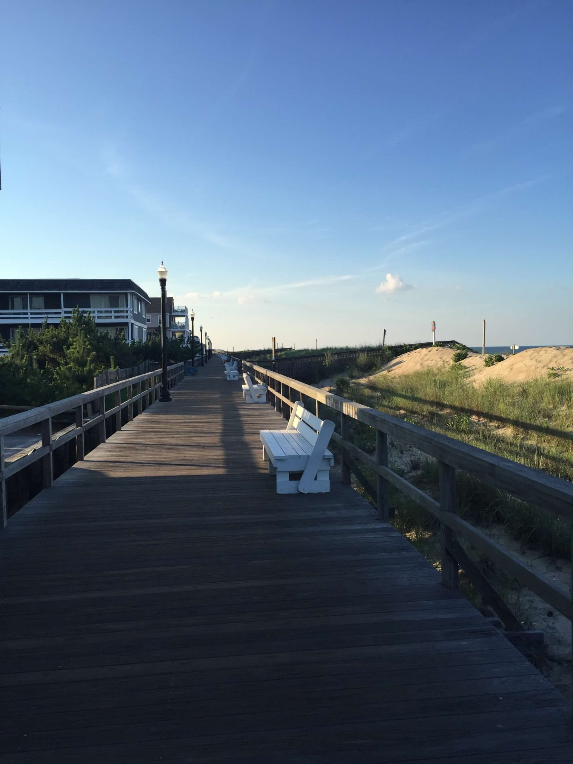 Bethany Beach Boardwalk with white benches.