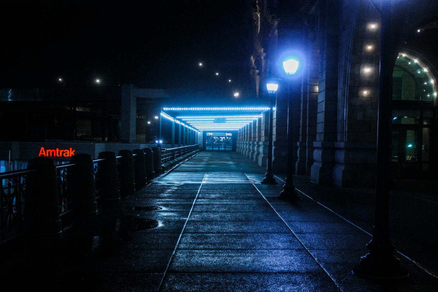 A street with a few lampposts in Washington DC at night.