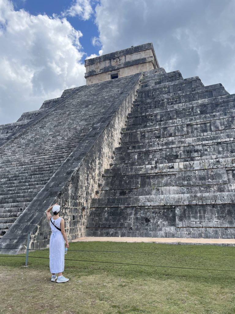 woman standing in front of chichen itza in mexico