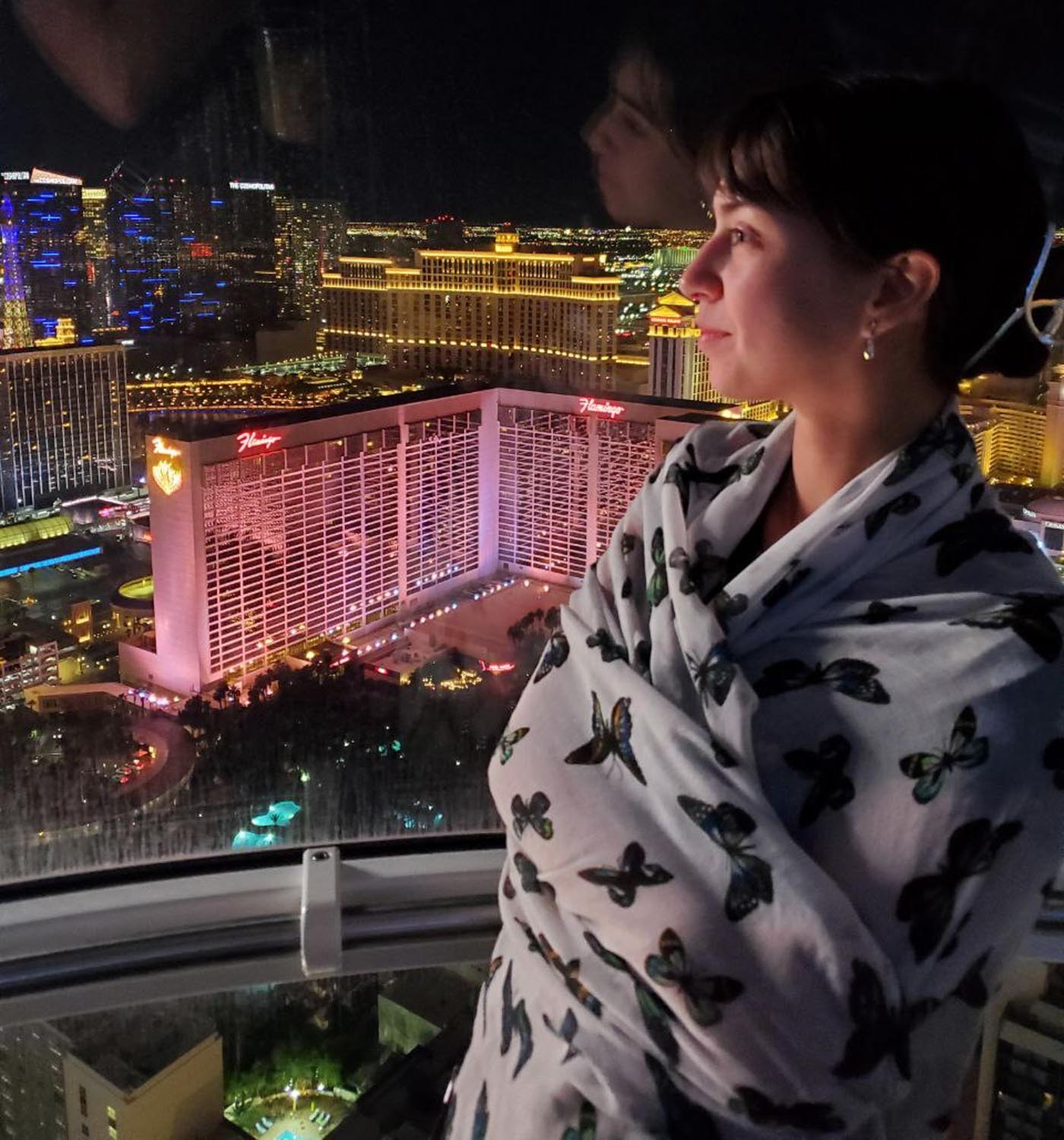A woman riding on a rollercoaster in Las Vegas admiring the view of buildings.