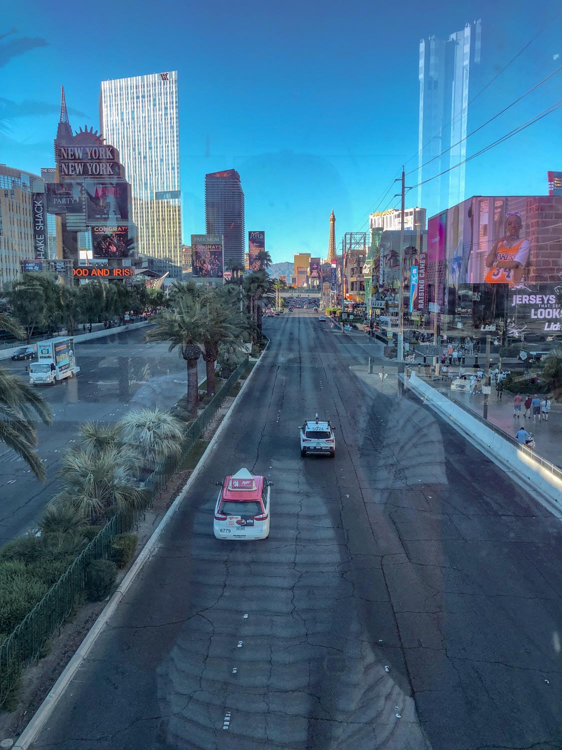 The view of the Las Vegas Strip buildings and road from a glass wall.