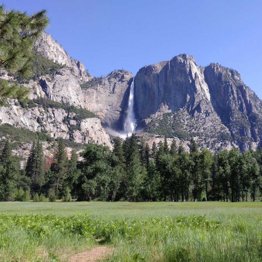 A national park with trees, mountains, and waterfalls.