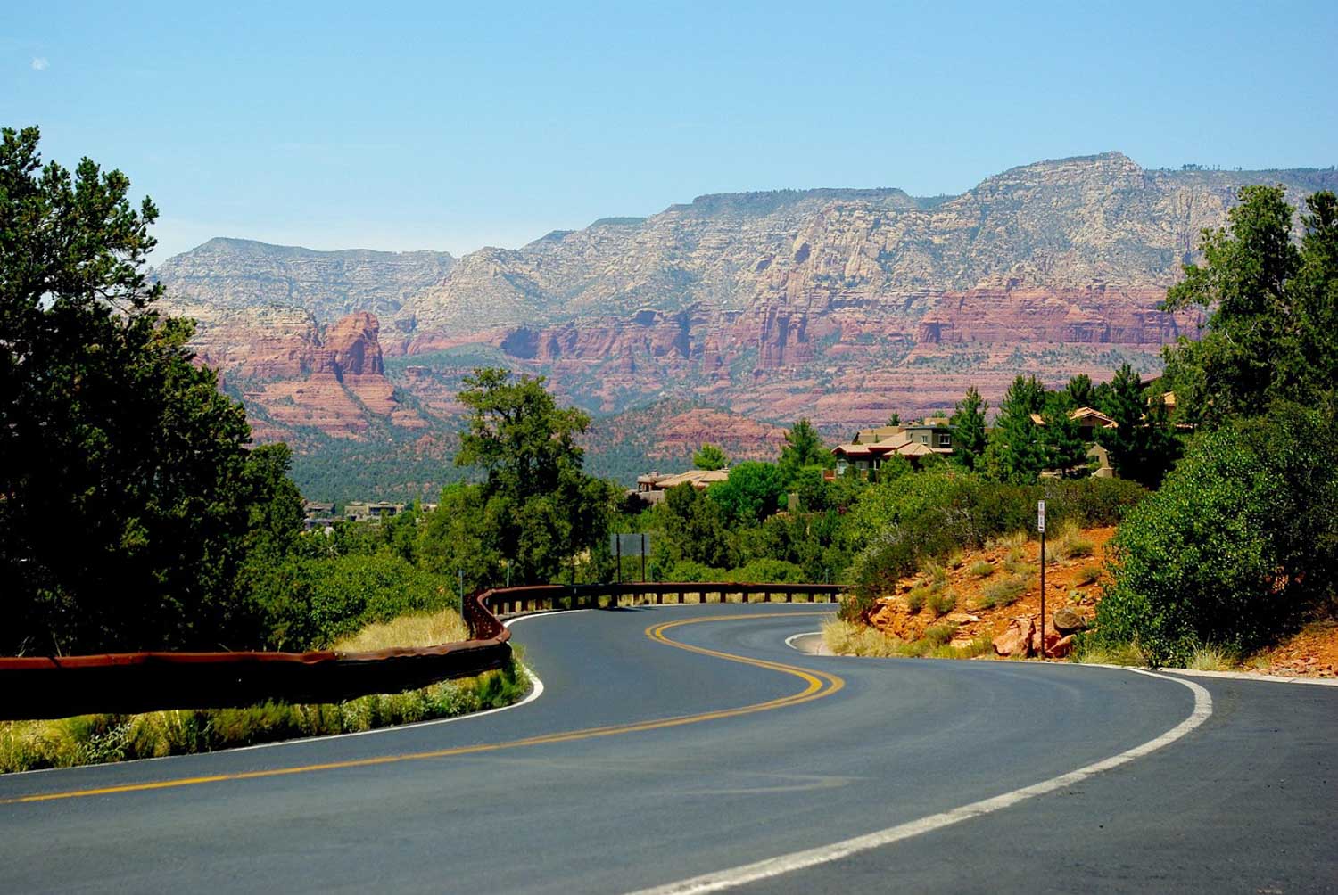 The road in Arizona with a view of trees and canyons.