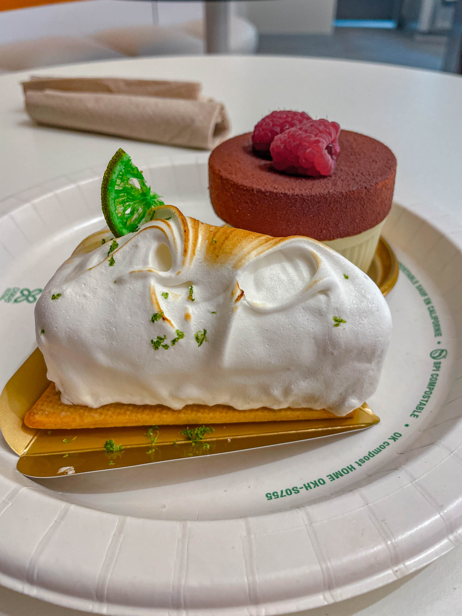 Cakes on a paper plate on a white table.