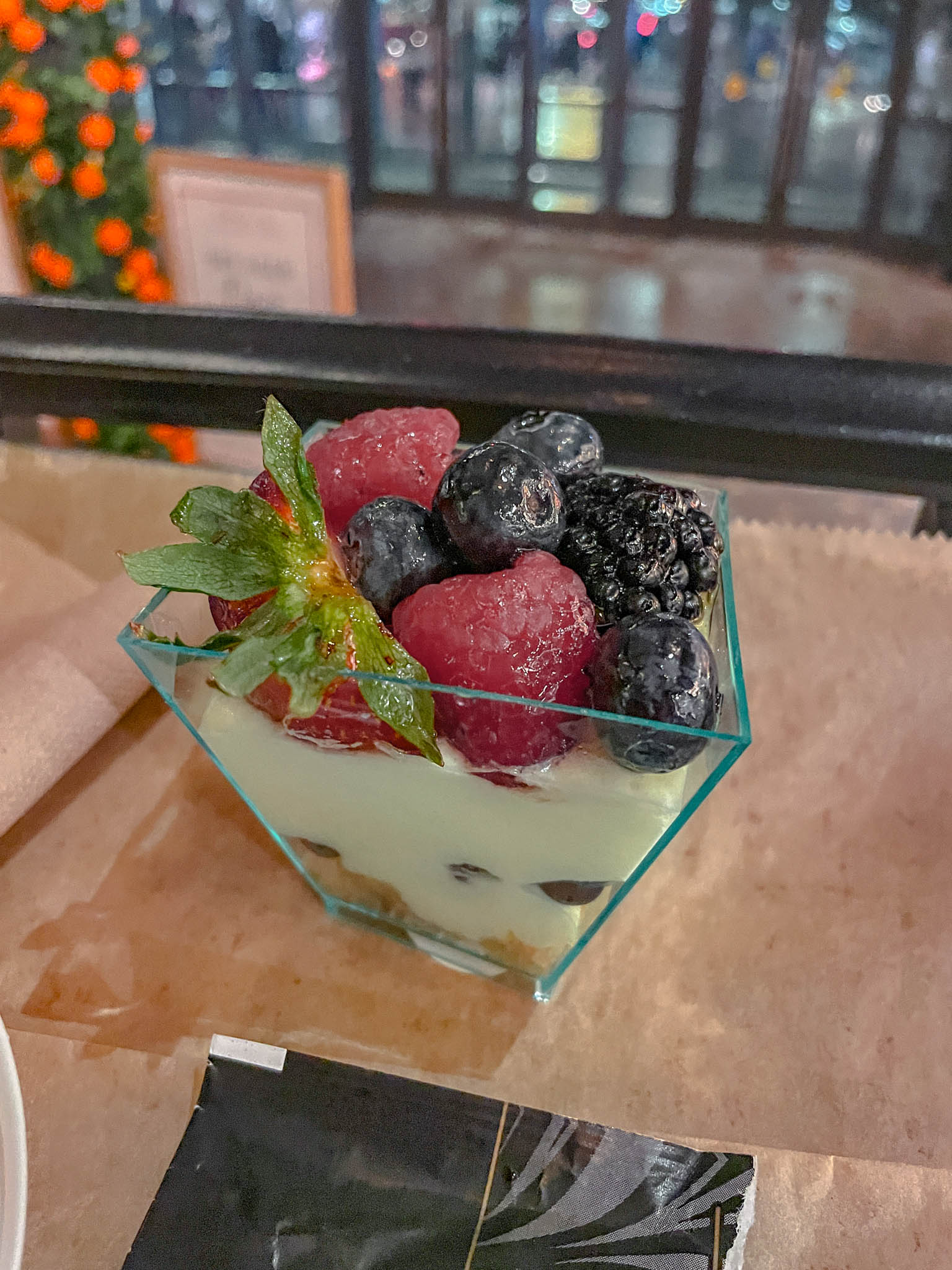 Panna cotta with fruit toppings on a geometric, glass bowl.