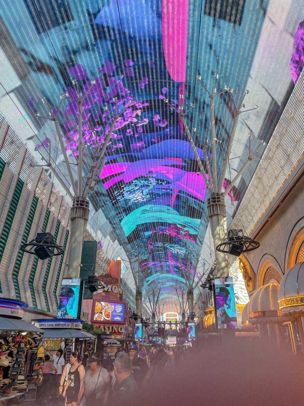 A roofed area in Las Vegas with a light show exhibit on the ceiling.