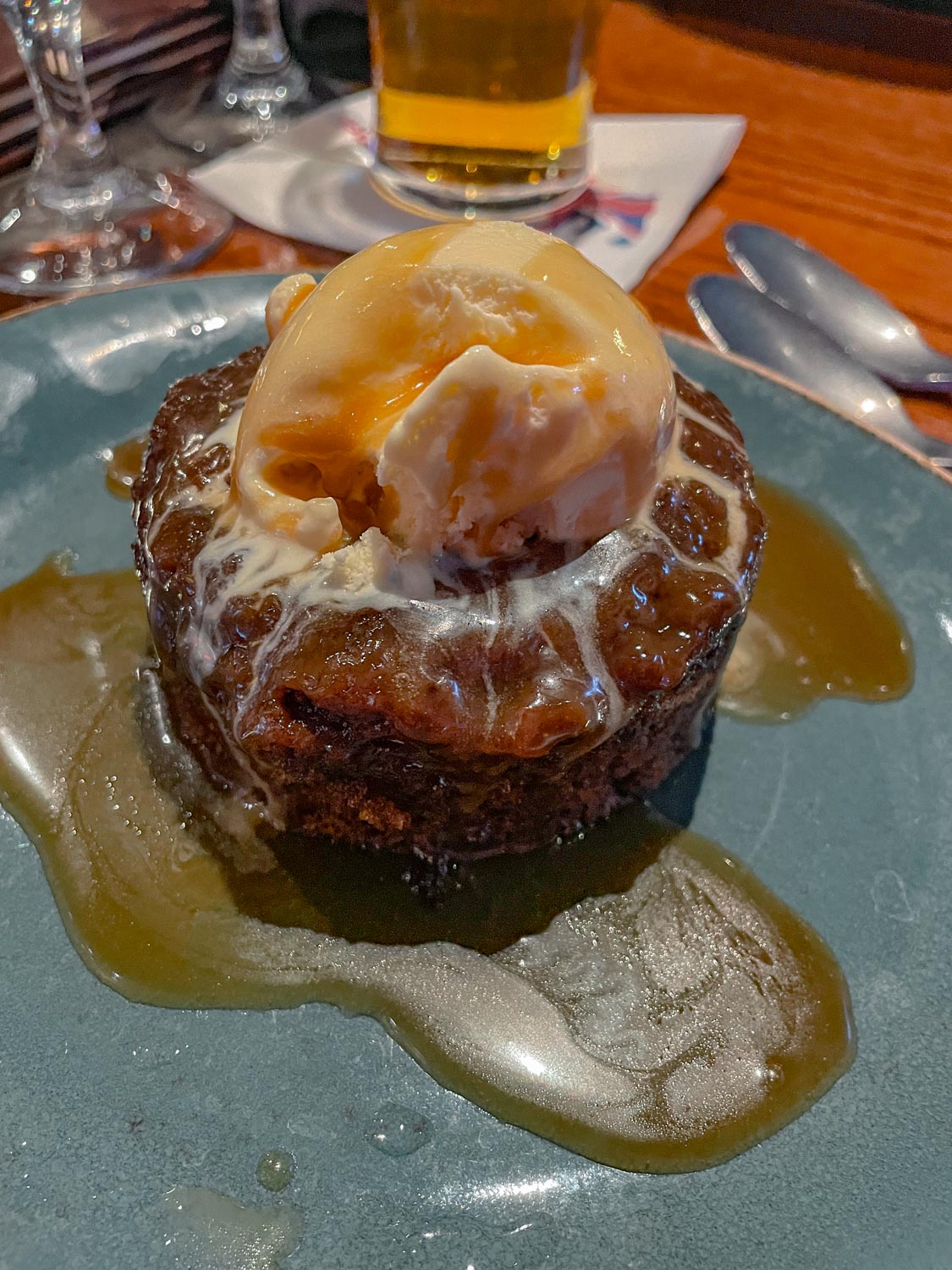 Chocolate cake with ice cream on top on a blue plate.