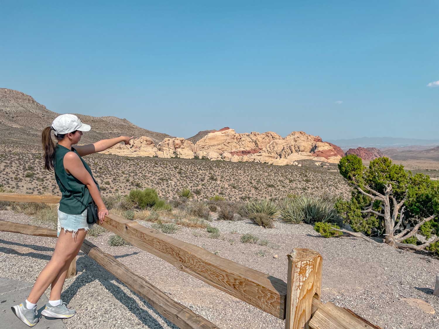 A woman pointing to Red Rock Canyon features.