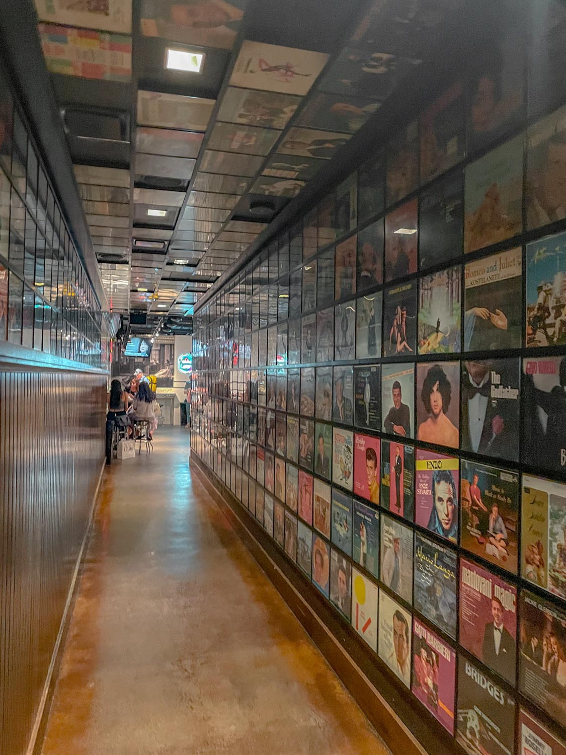 The hallway of a restaurant with records on the wall.