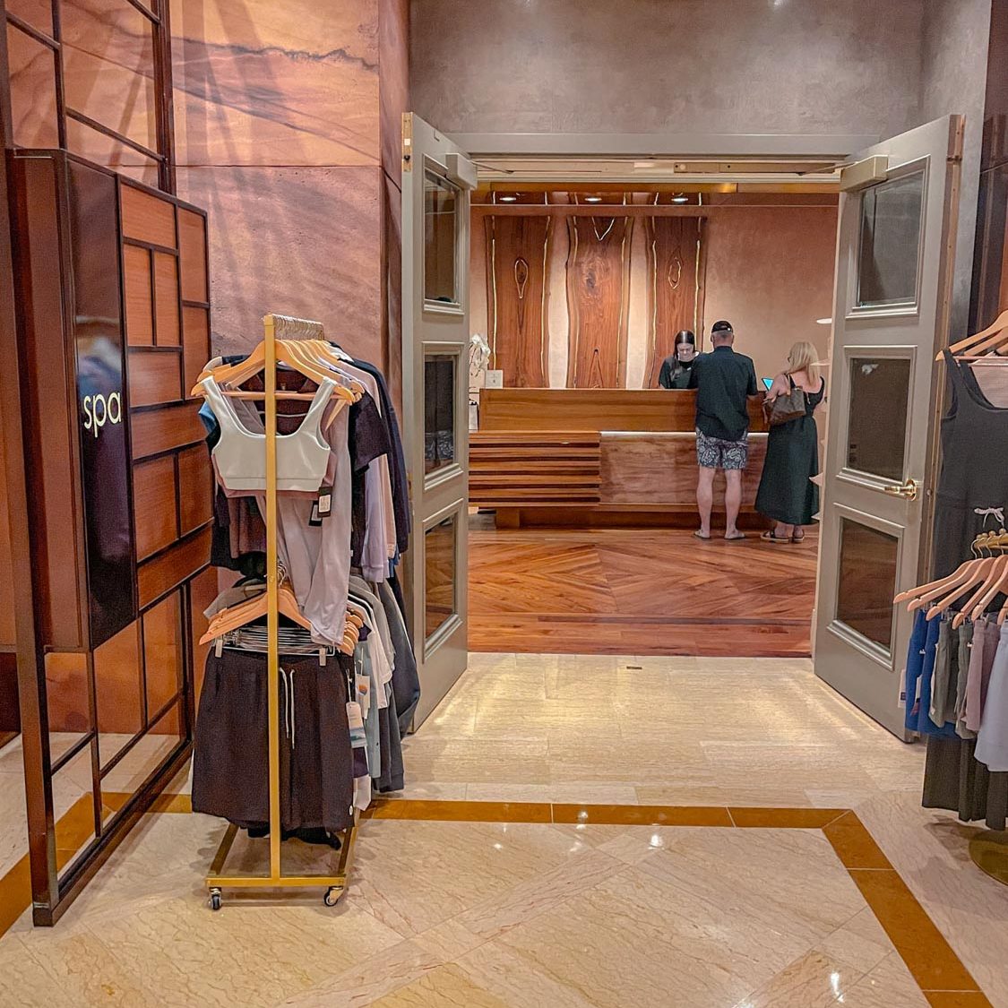 The entrance of a spa in a Las Vegas hotel with a couple of racks of clothes for sale.