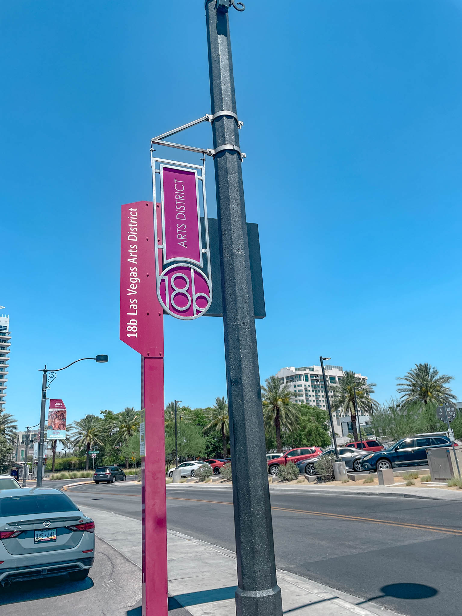 Pink post on a sidewalk that says "18b Las Vegas Arts District".