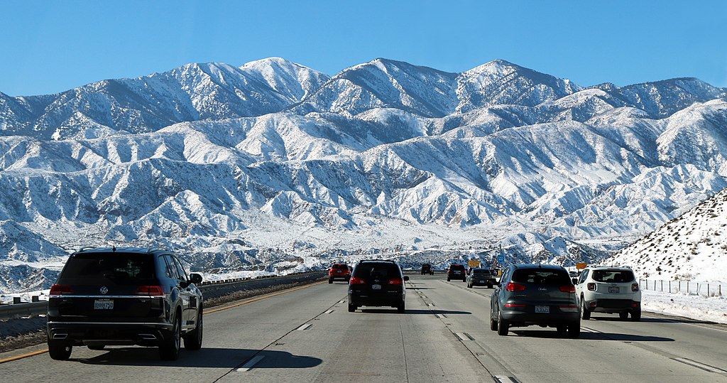 Roads on an interstate between Las Vegas and Los Angeles with a view of snowy mountains in the background.
