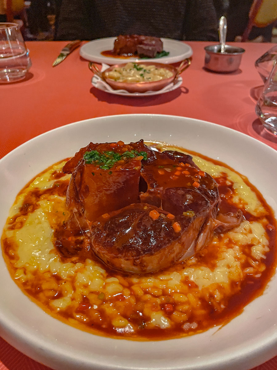 A cheesy meat dish on a plate at a fine dining restaurant.