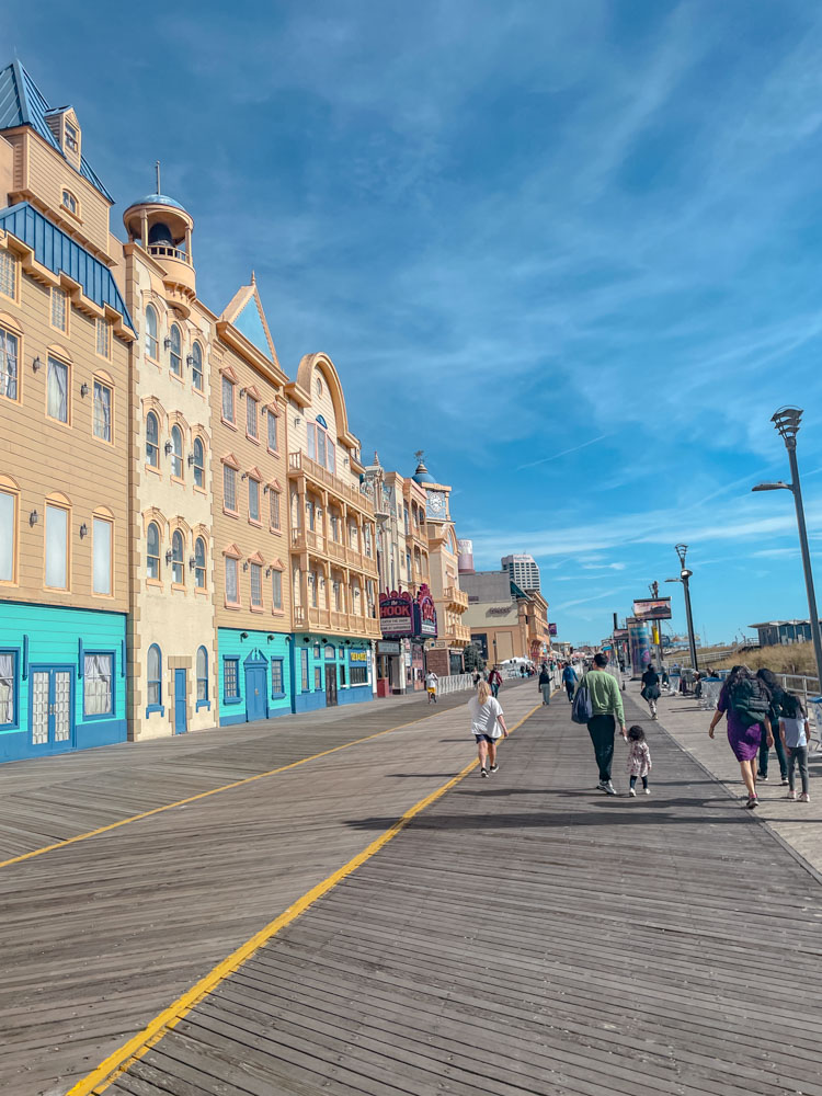 A few people walking on the boardwalk in Atlantic City.