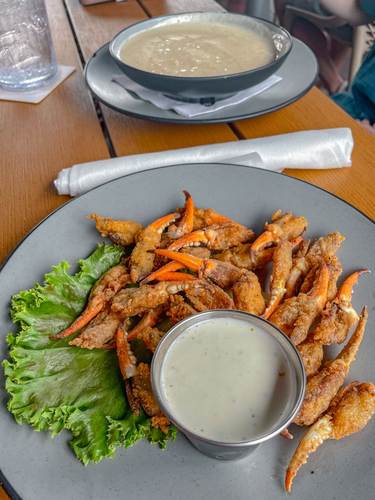 Fried crab legs with dip on a plate.
