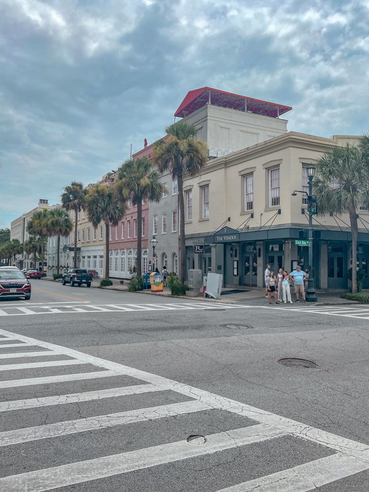 The intersection of streets in Charleston, South Carolina with people walking and shops.
