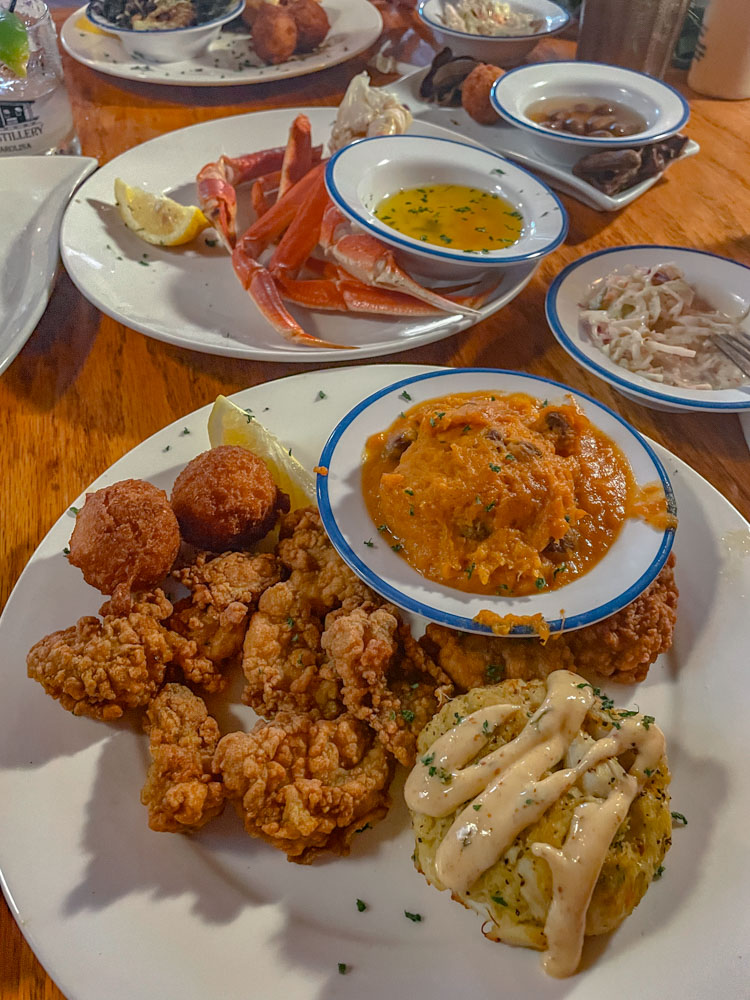 Seafood and fried food on plates on a table.