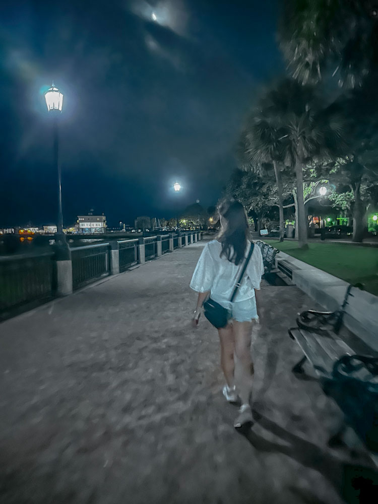 A woman walking at Waterfront Park at night in Charleston, South Carolina.