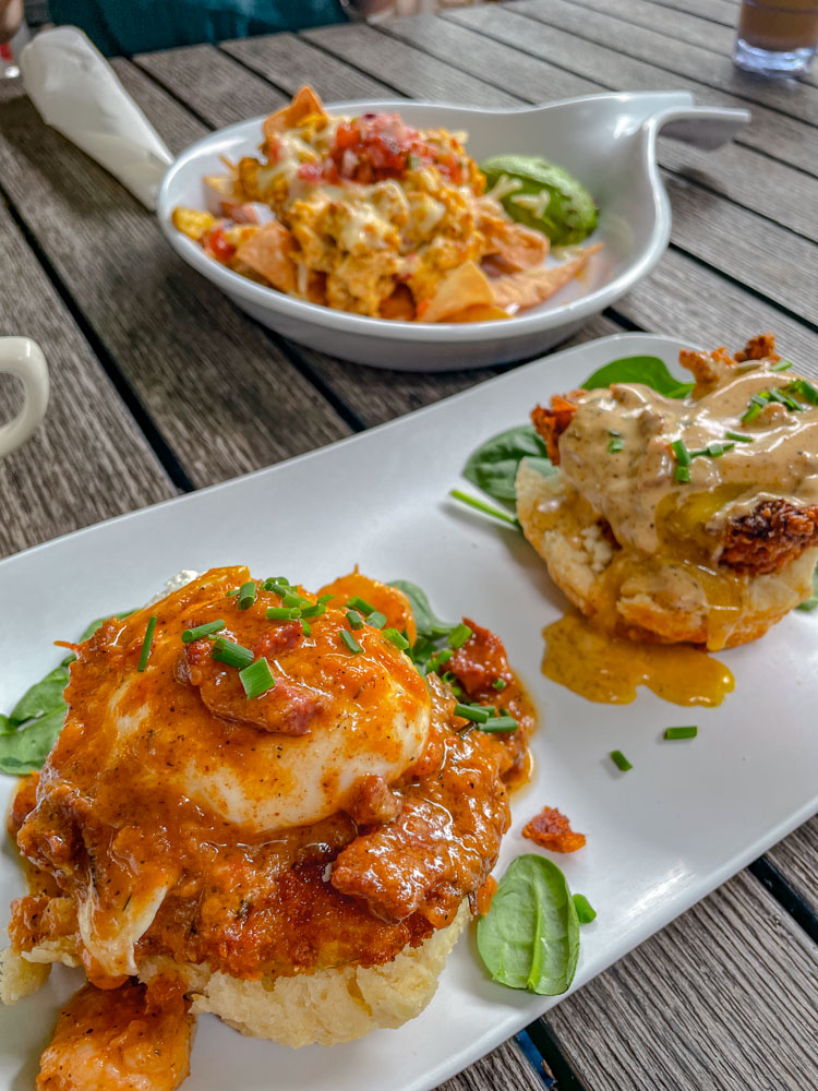 Various food with sauces on plates on a wooden table.
