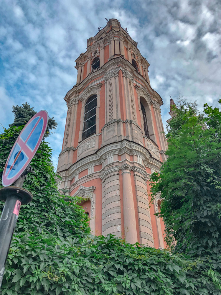 The facade of Church of St. Anne surrounded by plants.