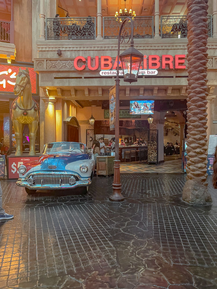 The storefront of a restaurant in an Atlantic City hotel with a vintage car in front of it.