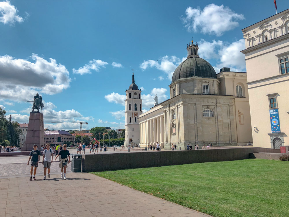 People walking outside Vilnius Cathedral in Lithuania.