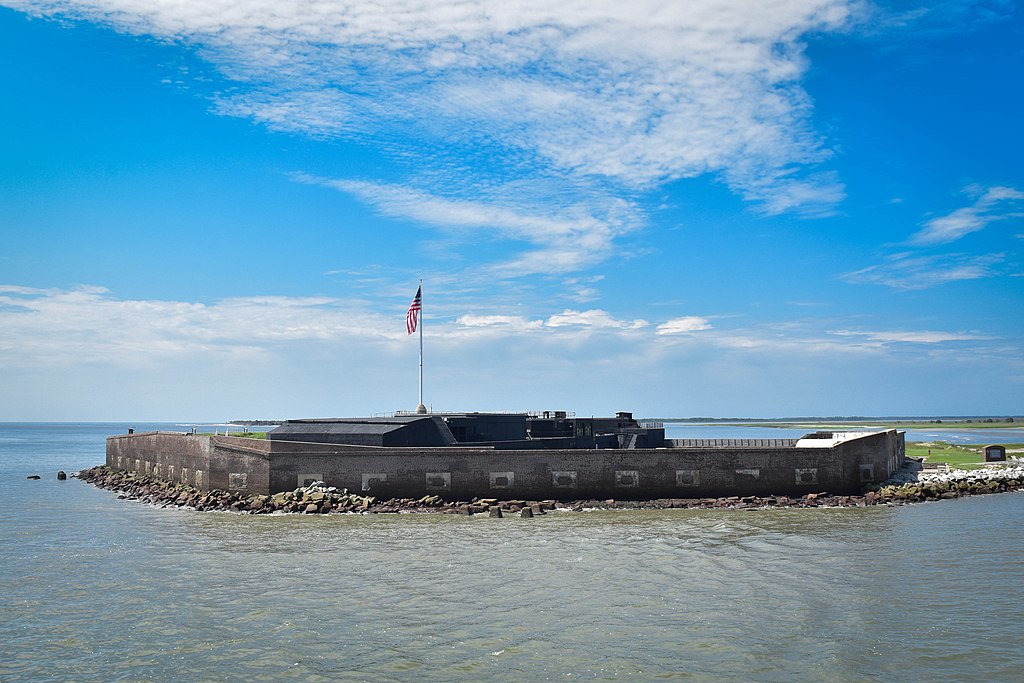 Fort Sumter with USA flag surrounded by water.