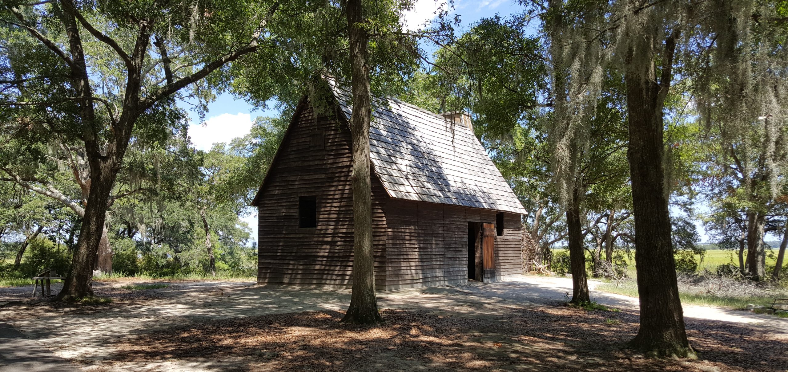 A wooden cabin surrounded by trees at Charles Towne Landing in Charleston, South Carolina.
