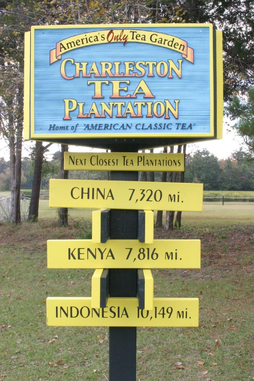 A blue and yellow sign that says "Charleston Tea Garden".