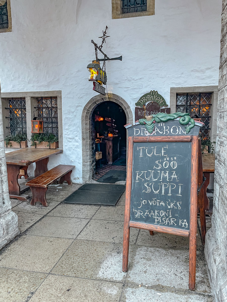 The entrance of a medieval-style pub in Tallinn, Estonia with a chalk board.