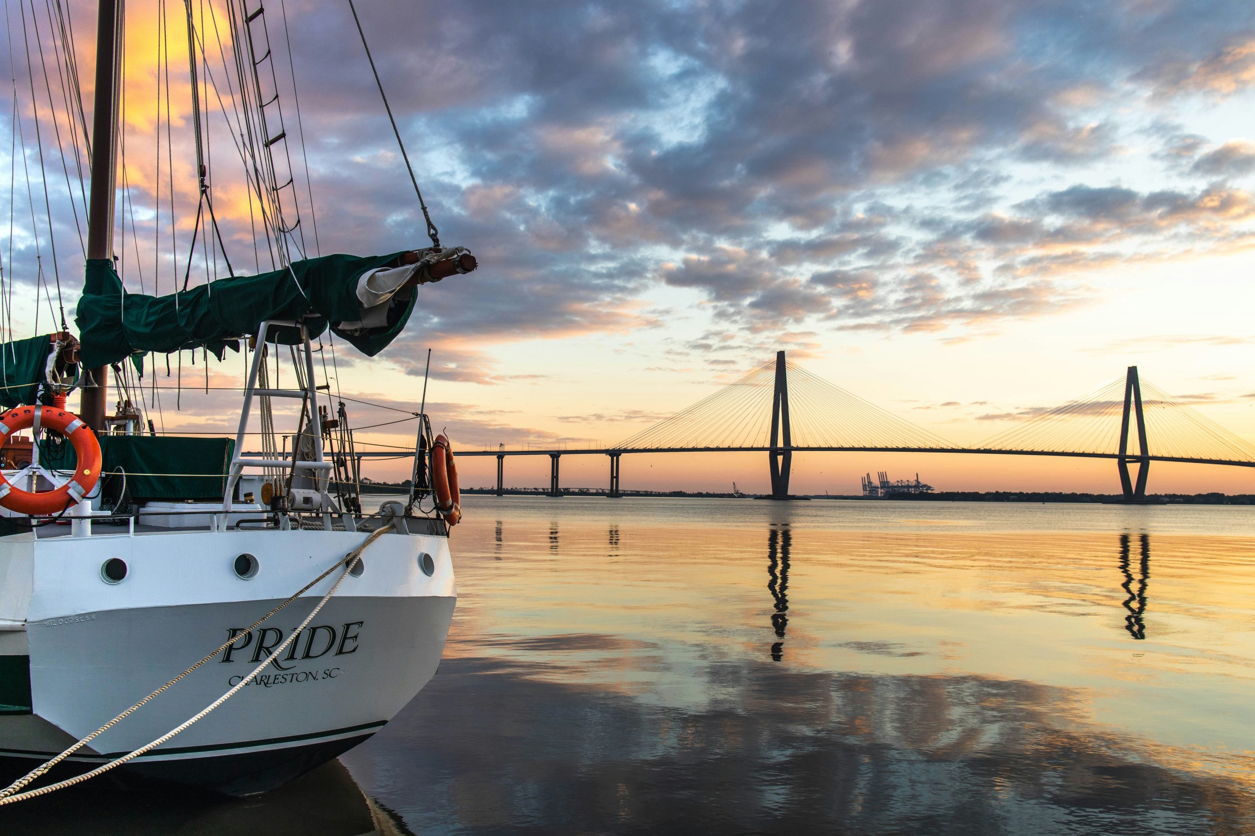 A boat on a dock with a view of Ravenel Bridge in Charleston, South Carolina.