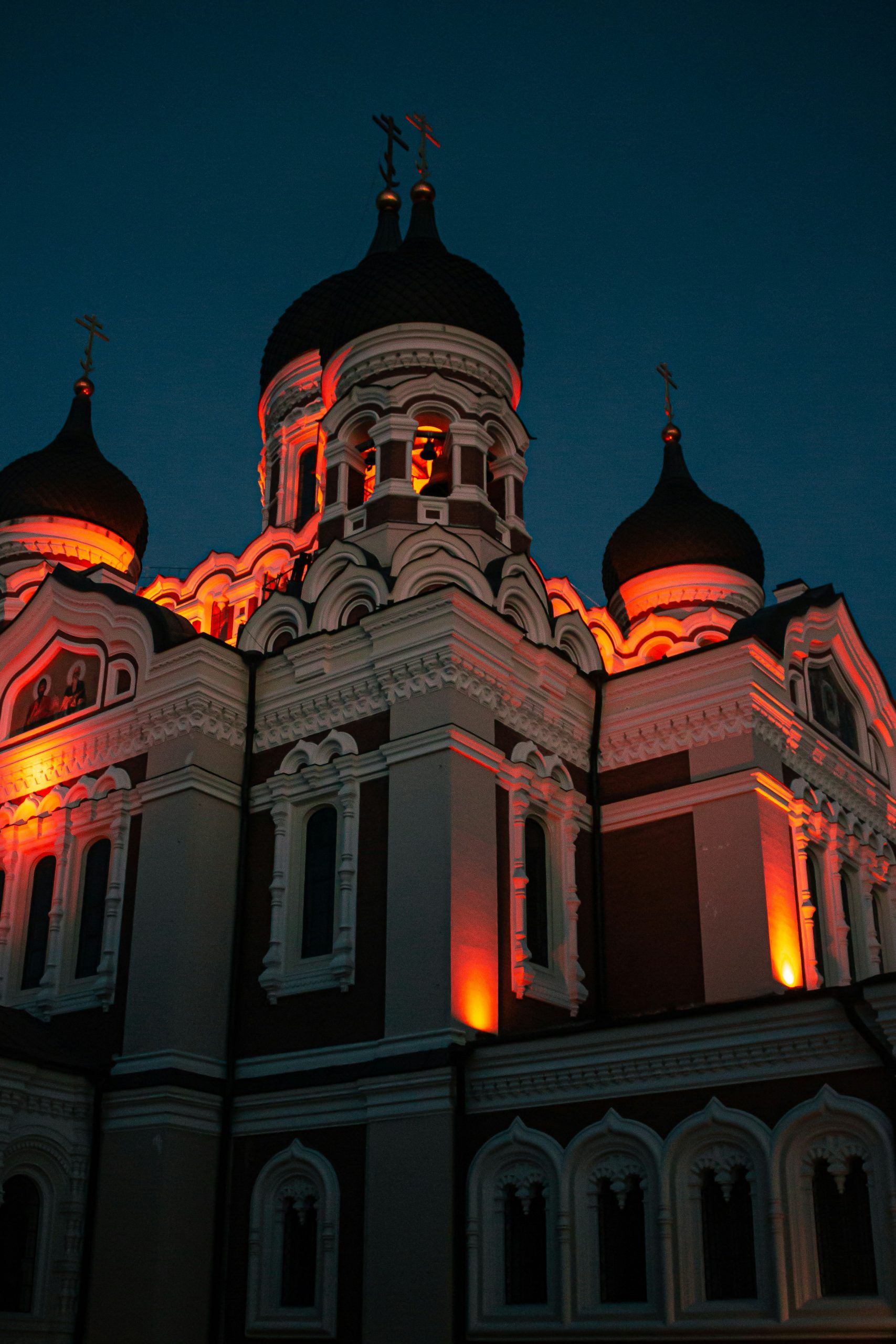 A church with white and brown paint in Tallinn, Estonia at night.