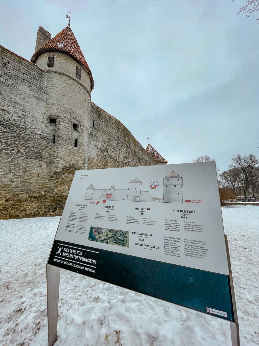 Museum guide in front of castle-like tower museum in winter in Tallinn, Estonia.
