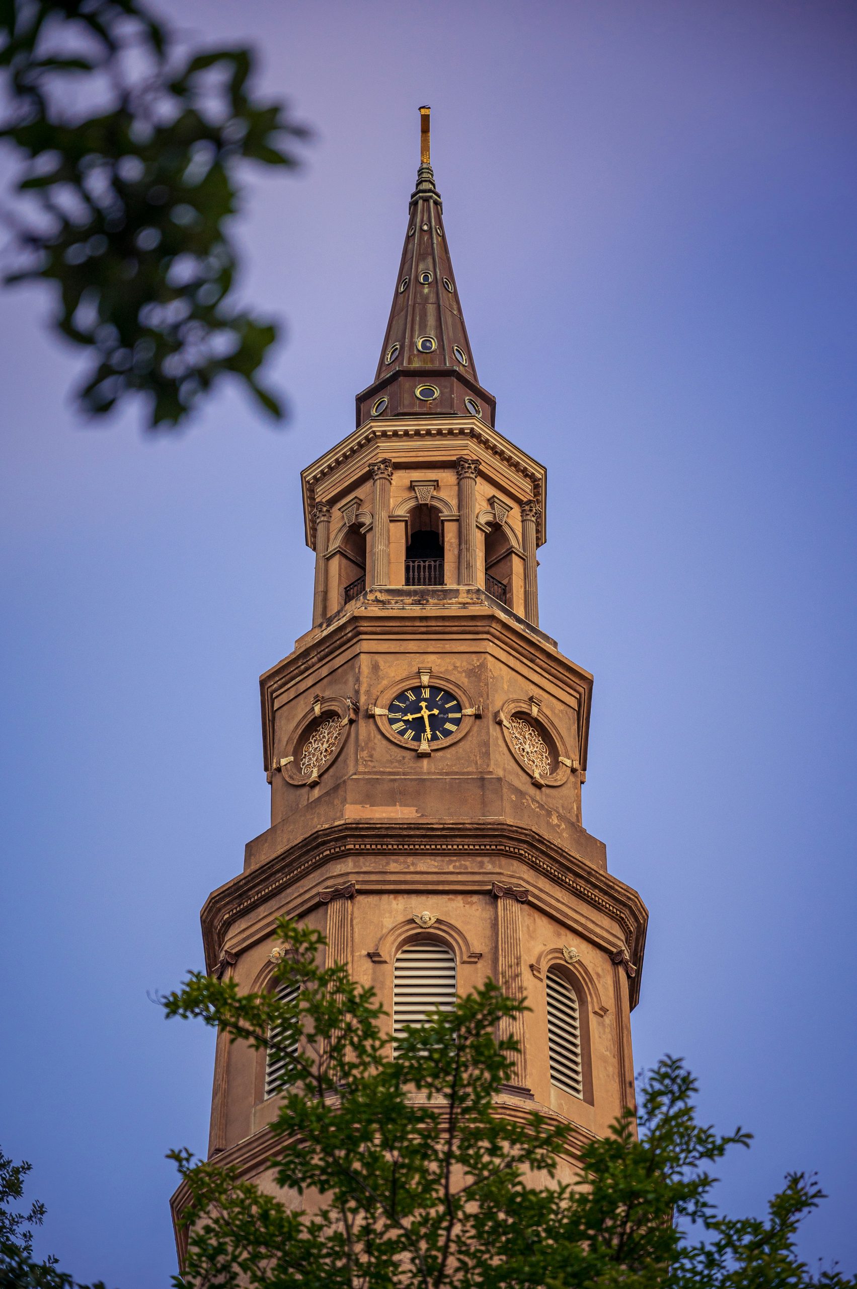 The watch tower of a church with brown facade in Charleston, South Carolina.