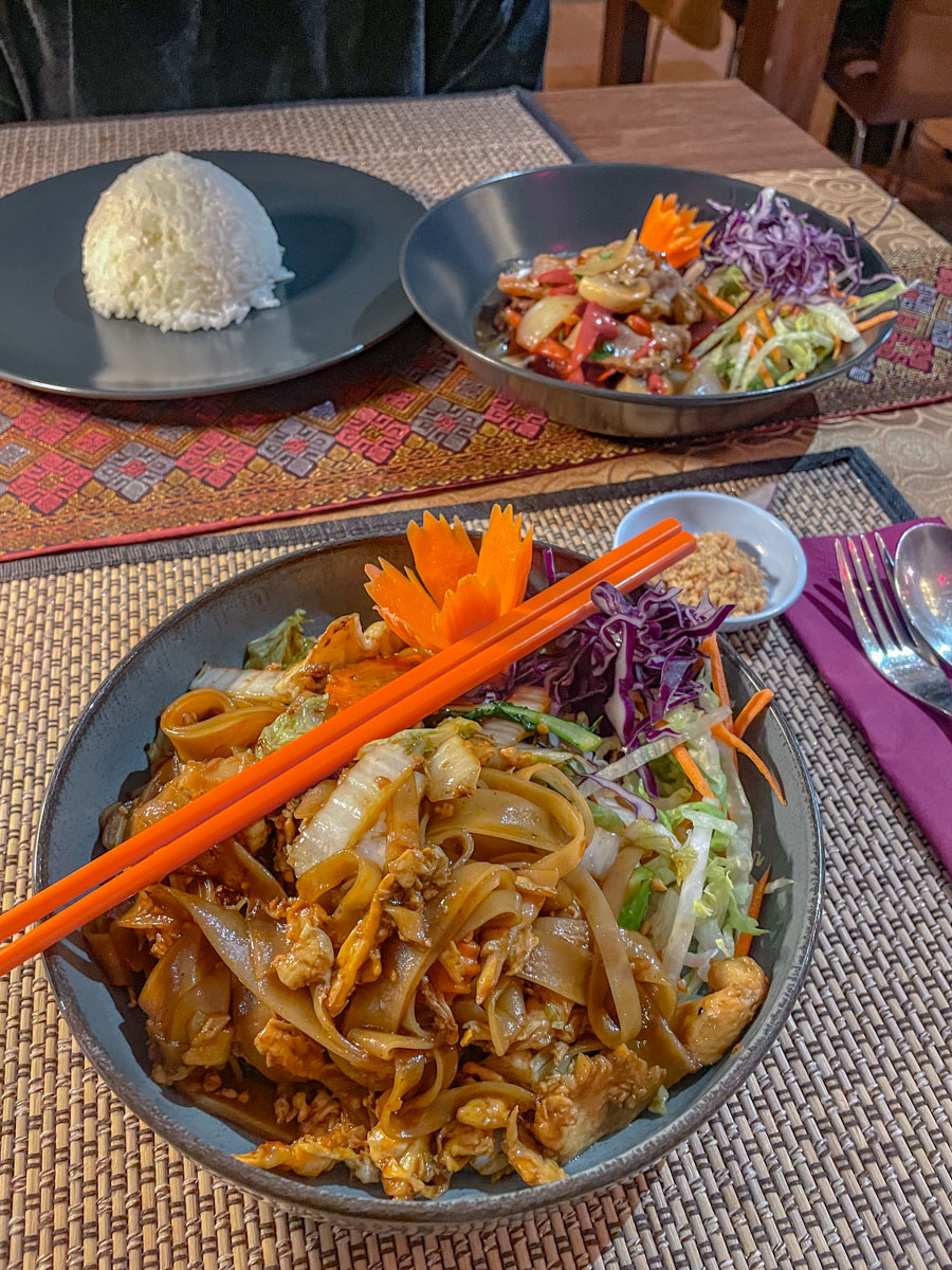 Vegetable dishes on bowls and a cup of rice on a plate.