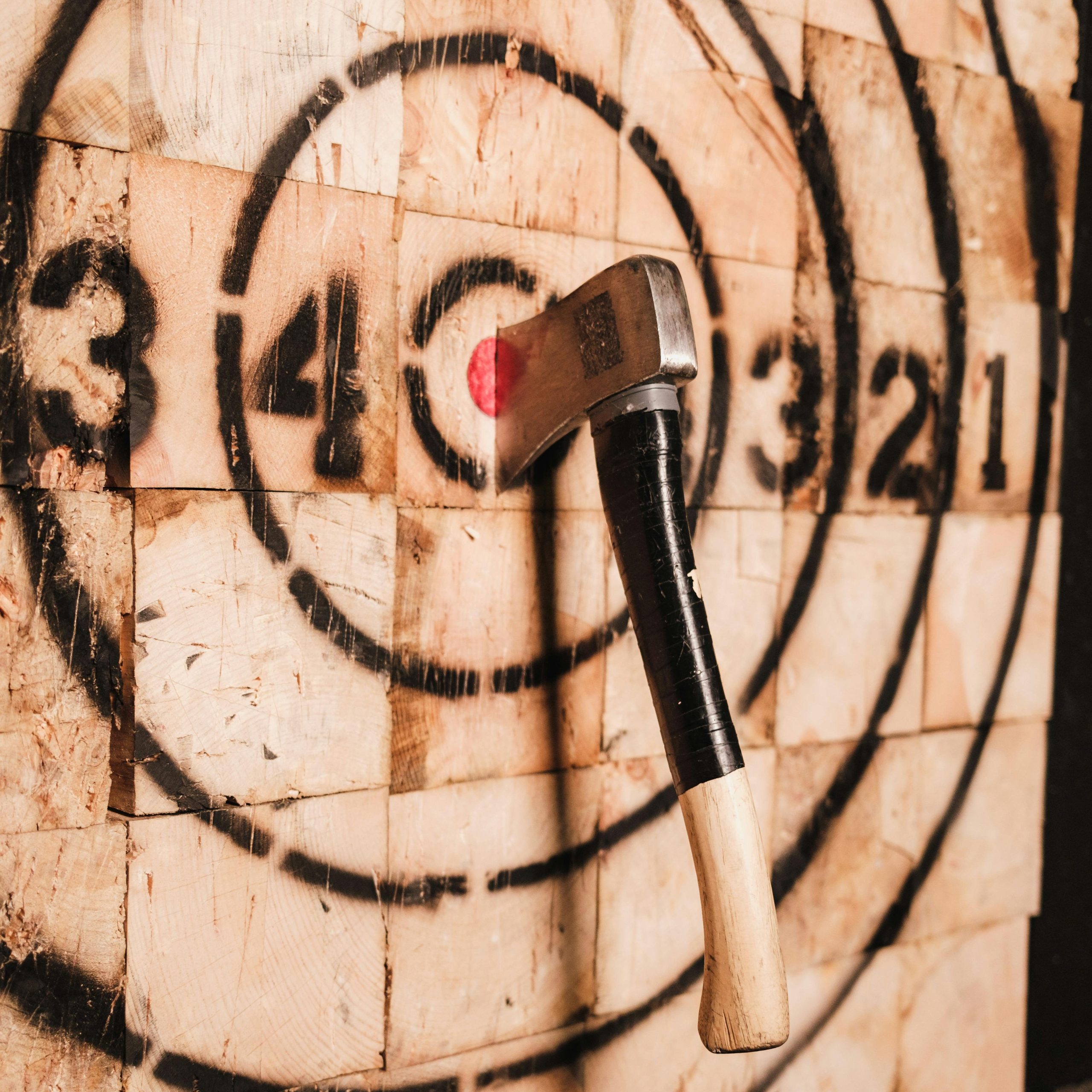 An axe attached to a wooden target.