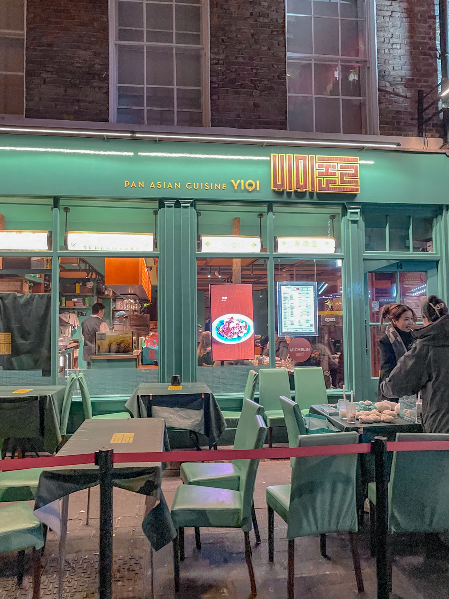 The entrance of an Asian restaurant with green exterior and al fresco dining area.