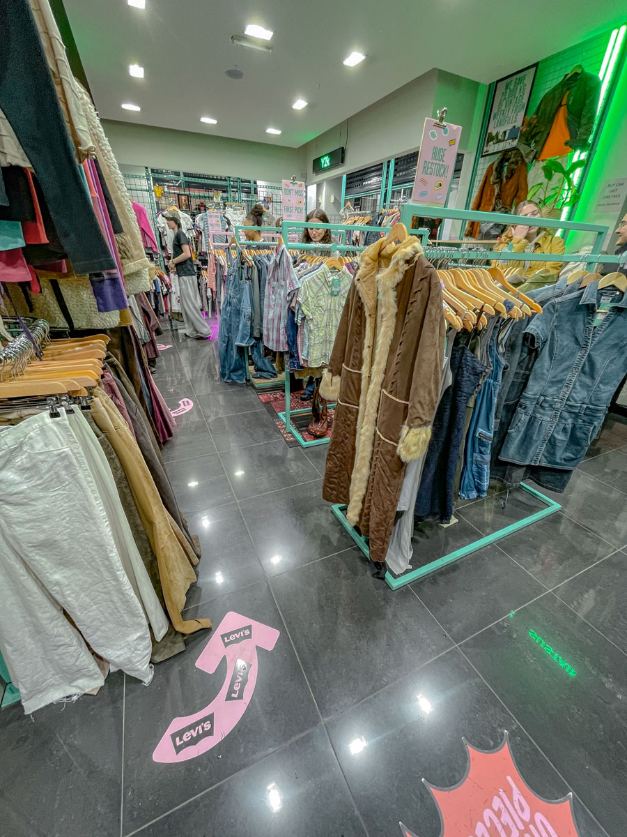 Racks of clothes in a thrift boutique shop.
