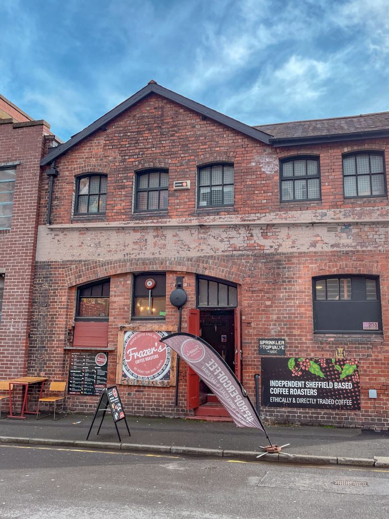 The entrance of a coffee shop on a brick building in Sheffield, UK.