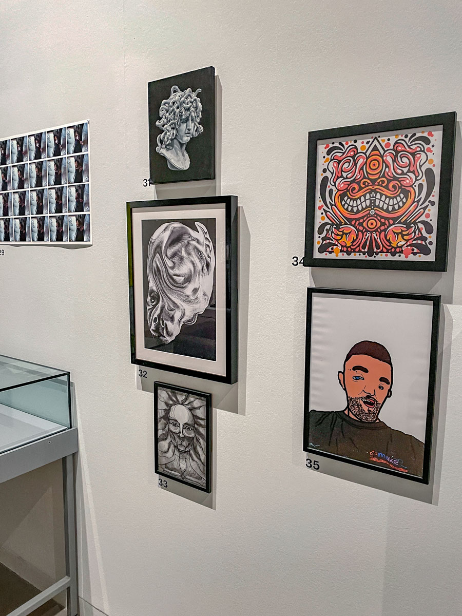 Various framed artworks on a white wall.