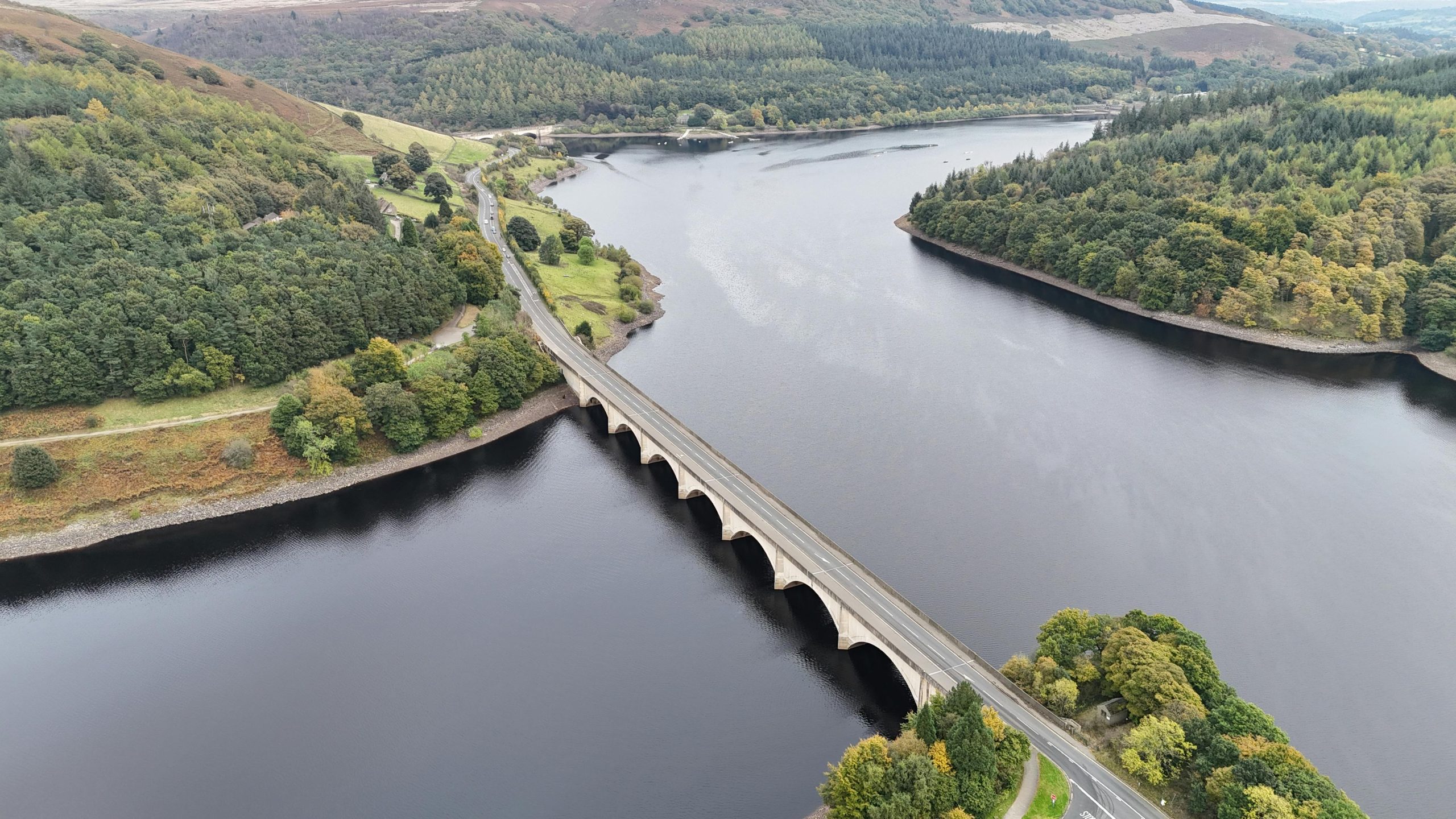 An aerial view of a scenic landscape and a bridge over a body of water.