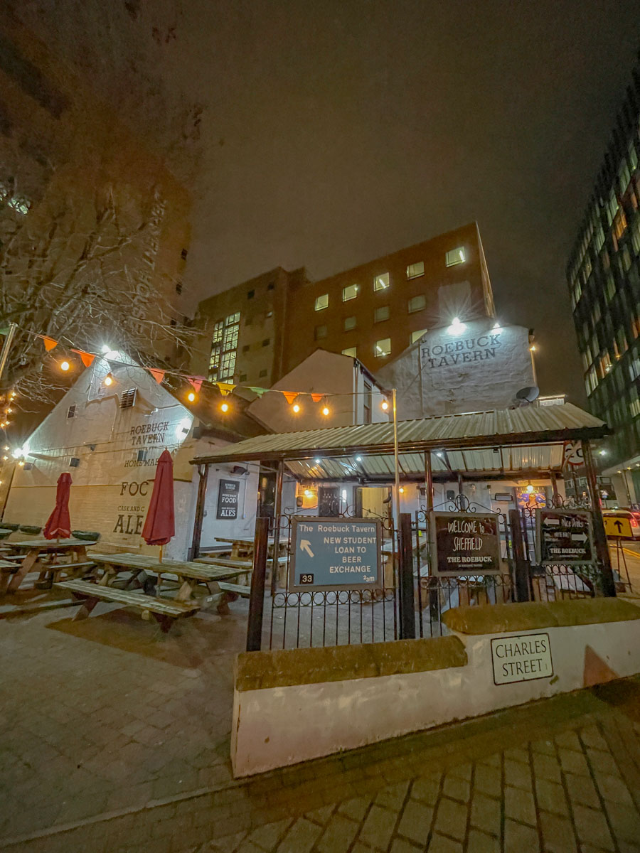 The outdoor dining area of a pub with wooden tables and benches in Sheffield.