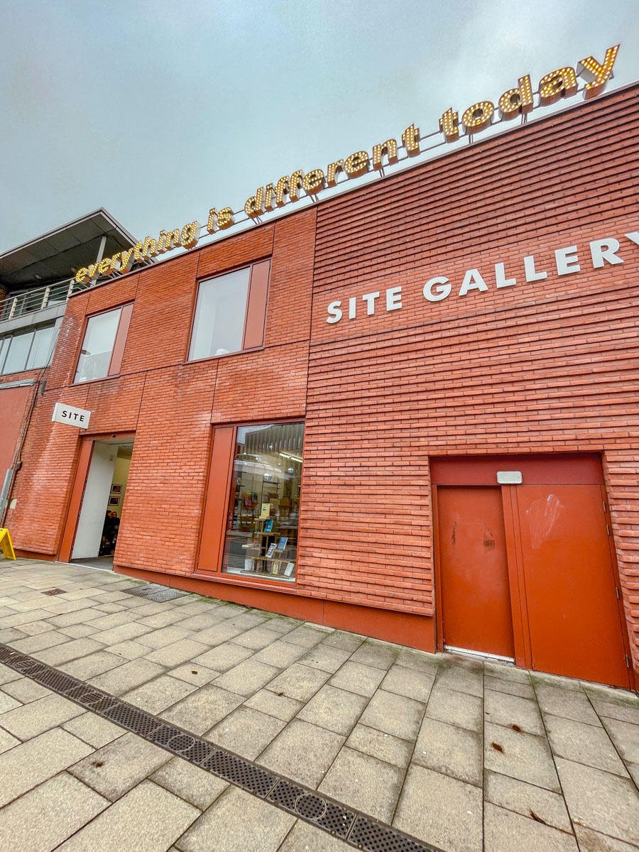 The entrance of a gallery in a building made of bricks.
