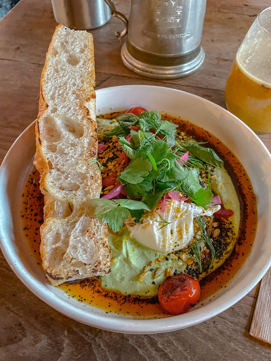 Bread with vegetables and dip on a white plate.