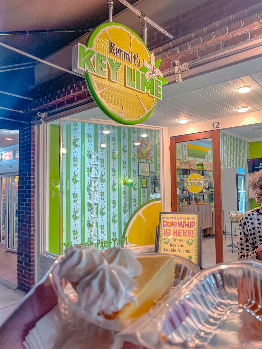 Key lime pie being held in front of a store sign that says "Kermit's Key Lime".