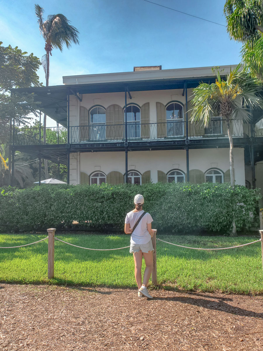 A woman standing outside Ernest Hemingway's home in Key West, Florida.
