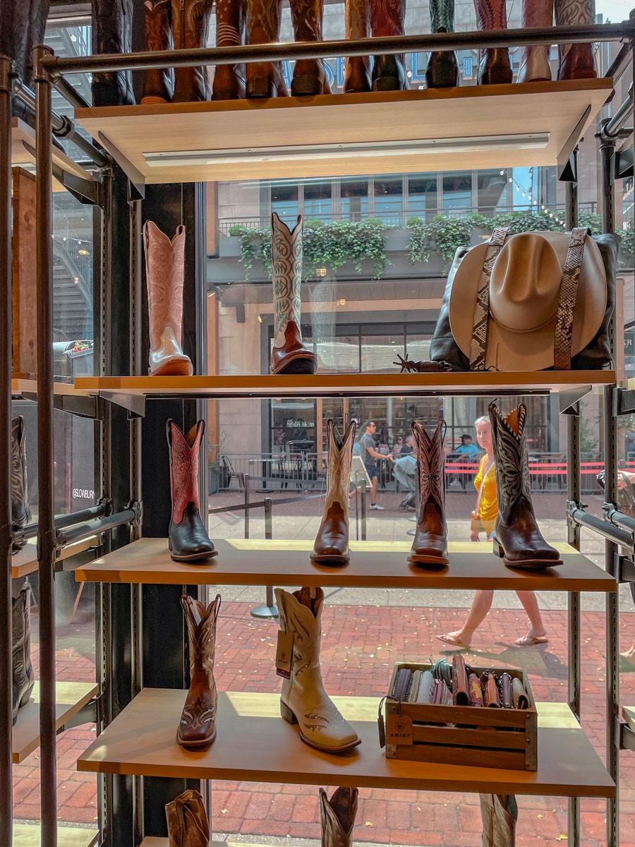 Boots, wallets, and a hat on a shelf by a window inside a shop in Nashville, Tennessee.